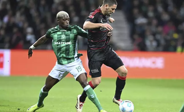 Werder's Derrick Koehn, left, and Berlin's Rani Khedira, right, challenge for the ball during the German Bundesliga soccer match between Werder Bremen and 1. FC Union Berlin in Bremen, Germany, Saturday, Dec. 21, 2024. (Carmen Jaspersen./dpa via AP)