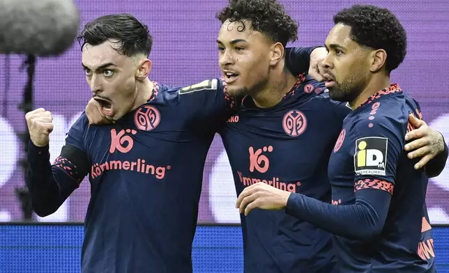 Mainz' scorer Paul Nebel, left, celebrates after scoring his side's second goal during the German Bundesliga soccer match between Eintracht Frankfurt and FSV Mainz 05 in Frankfurt, Germany, Saturday, Dec. 21, 2024. (Uwe Anspach/dpa via AP)