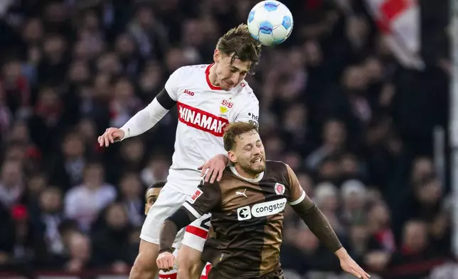 Stuttgart'sAnthony Rouault , left, and St. Pauli's Carlo Boukhalfa, right, challenge for the ball during the German Bundesliga soccer match between VfB Stuttgart and FC St. Pauli, in Stuttgart, Germany, Saturday, Dec. 21, 2024. (Tom Weller/dpa via AP)