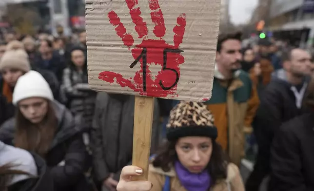 People stopping traffic stand in silence to commemorate the 15 victims of a railway roof collapse six weeks ago, demand accountability for the tragedy, in Belgrade, Serbia, Friday, Dec. 13, 2024. (AP Photo/Darko Vojinovic)