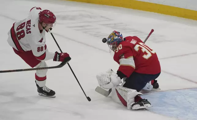 Florida Panthers goaltender Spencer Knight (30) stops a shot byy Carolina Hurricanes center Martin Necas (88) during the first period of an NHL hockey game, Saturday, Nov. 30, 2024, in Sunrise, Fla. (AP Photo/Marta Lavandier)