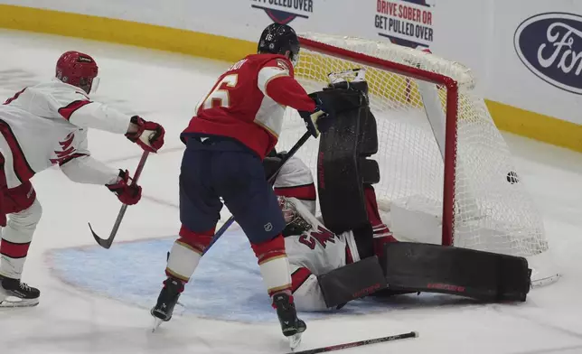 Carolina Hurricanes goaltender Spencer Martin (41) falls Florida Panthers defenseman Aaron Ekblad (5) scores a goal during the second period of an NHL hockey game, Saturday, Nov. 30, 2024, in Sunrise, Fla. (AP Photo/Marta Lavandier)