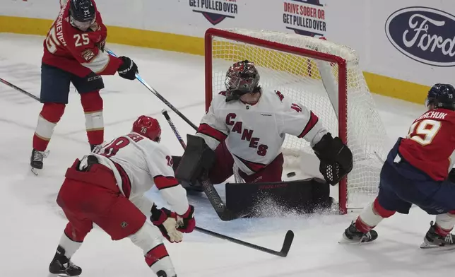 Florida Panthers right wing Mackie Samoskevich (25) scores a goal against Carolina Hurricanes goaltender Spencer Martin (41) during the second period of an NHL hockey game, Saturday, Nov. 30, 2024, in Sunrise, Fla. (AP Photo/Marta Lavandier)