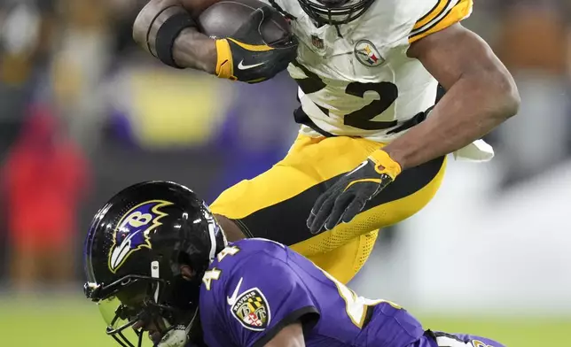 Pittsburgh Steelers running back Najee Harris (22) takes a hit from Baltimore Ravens cornerback Marlon Humphrey (44) during the second half of an NFL football game, Saturday, Dec. 21, 2024, in Baltimore. (AP Photo/Stephanie Scarbrough)