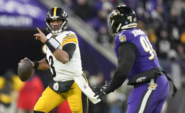 Pittsburgh Steelers quarterback Russell Wilson, left, gestures while scrambling against Baltimore Ravens defensive tackle Broderick Washington during the first half of an NFL football game, Saturday, Dec. 21, 2024, in Baltimore. (AP Photo/Stephanie Scarbrough)