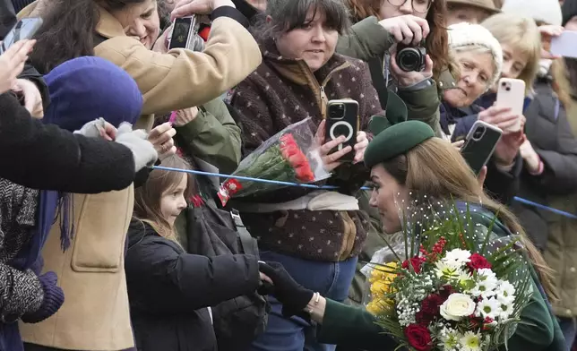 Kate, Princess of Wales shakes hands with a little girl as she greet members of the public after attending the Christmas day service at St Mary Magdalene Church in Sandringham in Norfolk, England, Wednesday, Dec. 25, 2024. (AP Photo/Jon Super)