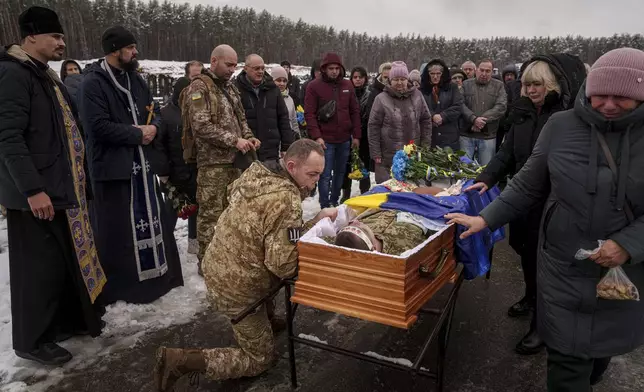 FILE - During a funeral ceremony in Irpin, the Kyiv region of Ukraine, on Nov. 21, serviceman Roman bids farewell to a comrade from the 47th Brigade -- Serhii Solovyov -- who was killed during fighting with Russian Forces in Kursk on November 12, 2024. (AP Photo/Evgeniy Maloletka, File)