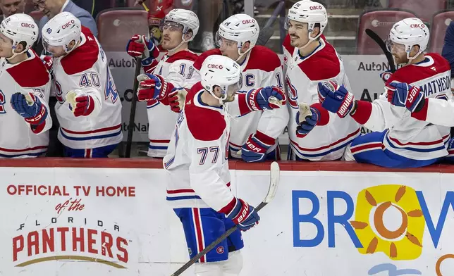 Montreal Canadiens center Kirby Dach (77) celebrates with teammates at the bench after scoring a goal during the second period of an NHL hockey game against the Florida Panthers on Saturday, Dec. 28, 2024, in Sunrise, Fla. (David Santiago/Miami Herald via AP)