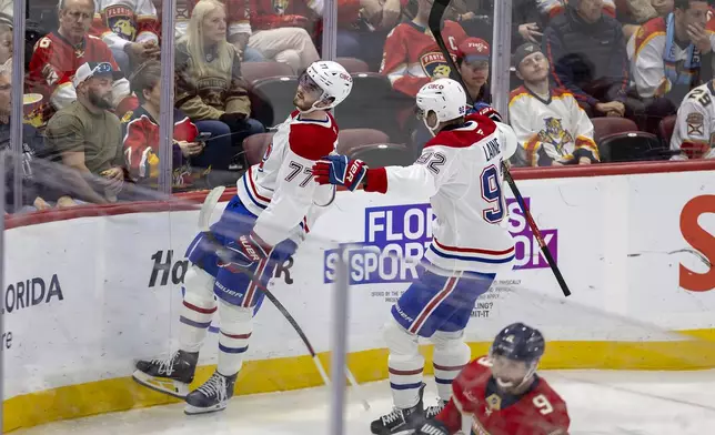 Montreal Canadiens center Kirby Dach (77) celebrates with teammate Patrik Laine (92) after scoring a goal during the second period of an NHL hockey game against the Florida Panthers on Saturday, Dec. 28, 2024, in Sunrise, Fla. (David Santiago/Miami Herald via AP)