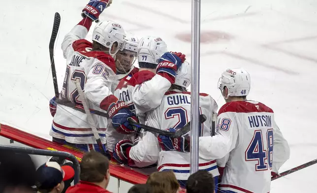 Montreal Canadiens center Kirby Dach (77) celebrates with teammates after scoring his second goal during the second period of an NHL hockey game against the Florida Panthers on Saturday, Dec. 28, 2024, in Sunrise, Fla. (David Santiago/Miami Herald via AP)