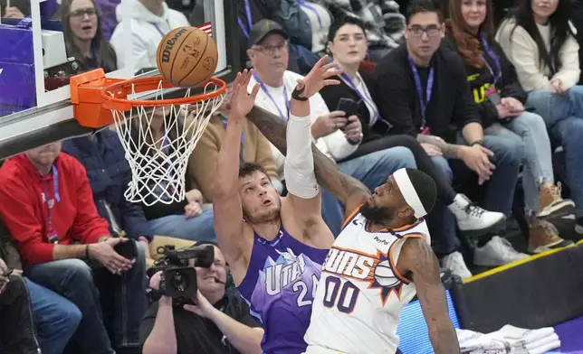 Utah Jazz center Walker Kessler (24) defends against Phoenix Suns forward Royce O'Neale (00) during the first half of an NBA basketball game Friday, Dec. 13, 2024, in Salt Lake City. (AP Photo/Rick Bowmer)