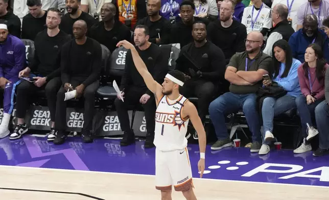 Phoenix Suns guard Devin Booker (1) followings through after scoring a 3-pointer against the Utah Jazz during the first half of an NBA basketball game Friday, Dec. 13, 2024, in Salt Lake City. (AP Photo/Rick Bowmer)