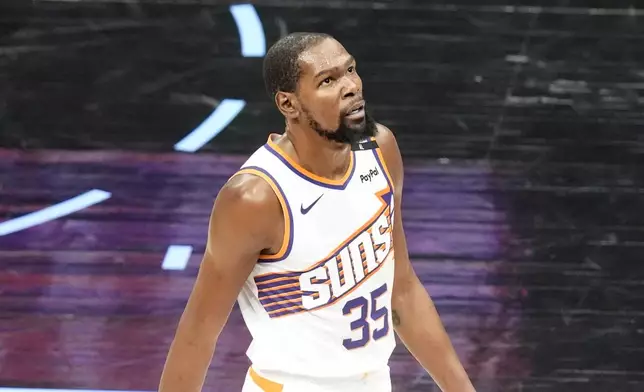 Phoenix Suns forward Kevin Durant (35) looks at the scoreboard during the second half of an NBA basketball game against the Utah Jazz Friday, Dec. 13, 2024, in Salt Lake City. (AP Photo/Rick Bowmer)