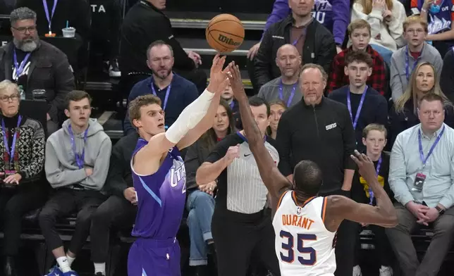 Utah Jazz forward Lauri Markkanen, left, shoots as Phoenix Suns forward Kevin Durant (35) defends during the first half of an NBA basketball game Friday, Dec. 13, 2024, in Salt Lake City. (AP Photo/Rick Bowmer)