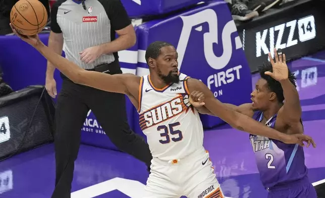 Utah Jazz guard Collin Sexton (2) defends against Phoenix Suns forward Kevin Durant (35) during the first half of an NBA basketball game Friday, Dec. 13, 2024, in Salt Lake City. (AP Photo/Rick Bowmer)