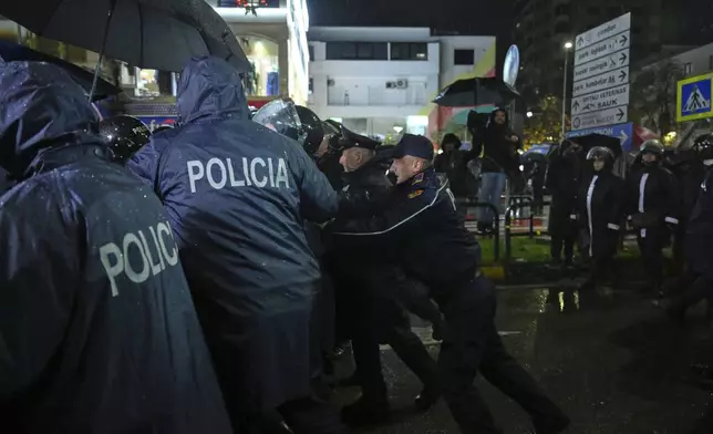 Police block opposition protesters during an anti-government rally asking for a technocratic caretaker Cabinet, in Tirana, Albania, Monday, Dec. 23, 2024. (AP Photo/Vlasov Sulaj)