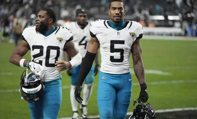 Jacksonville Jaguars safety Andre Cisco (5) and Jaguars safety Daniel Thomas (20) walk off the field after an NFL football game loss against the Las Vegas Raiders Sunday, Dec. 22, 2024, in Las Vegas. The Raiders won 19-14.(AP Photo/John Locher)