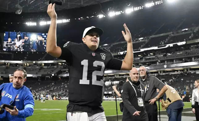 Las Vegas Raiders quarterback Aidan O'Connell smiles as he waves to the crowd as he runs off the field after an NFL football game against the Jacksonville Jaguars Sunday, Dec. 22, 2024, in Las Vegas. The Raiders won 19-14.(AP Photo/David Becker)