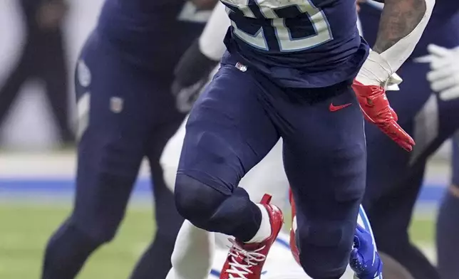 Tennessee Titans running back Tony Pollard (20) runs past Indianapolis Colts safety Julian Blackmon (32) during the first half of an NFL football game Sunday, Dec. 22, 2024, in Indianapolis. (AP Photo/Michael Conroy)