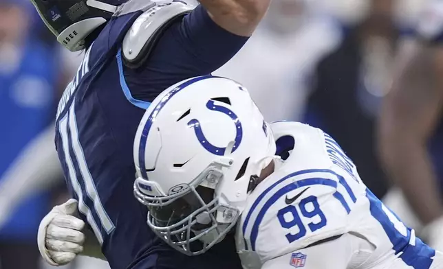 Indianapolis Colts defensive tackle DeForest Buckner (99) pressures Tennessee Titans quarterback Mason Rudolph (11) as he throws during the first half of an NFL football game Sunday, Dec. 22, 2024, in Indianapolis. (AP Photo/Michael Conroy)