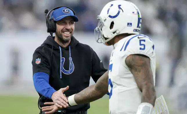 Indianapolis Colts head coach Shane Steichen, left, congratulates quarterback Anthony Richardson (5) after a touchdown during the first half of an NFL football game against the Tennessee Titans, Sunday, Dec. 22, 2024, in Indianapolis. (AP Photo/Darron Cummings)