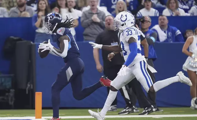 Tennessee Titans wide receiver Calvin Ridley, left, scores a past Indianapolis Colts cornerback Samuel Womack III (33) during the first half of an NFL football game Sunday, Dec. 22, 2024, in Indianapolis. (AP Photo/Michael Conroy)