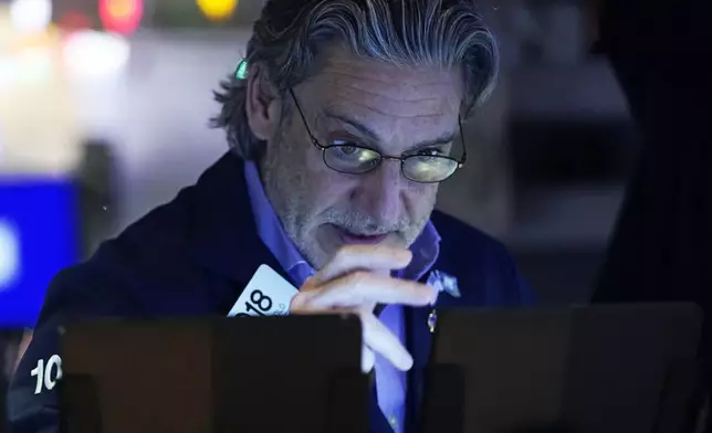 Trader John Romolo works on the floor of the New York Stock Exchange, Wednesday, Dec. 18, 2024. (AP Photo/Richard Drew)