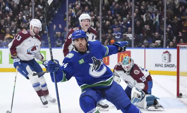 Vancouver Canucks' Kiefer Sherwood (44) celebrates his second goal against Colorado Avalanche goalie MacKenzie Blackwood (39) as Valeri Nichushkin (13) and Cale Makar (8) look on during the second period of an NHL hockey game in Vancouver, British Columbia on Monday, Dec. 16, 2024. (Darryl Dyck/The Canadian Press via AP)