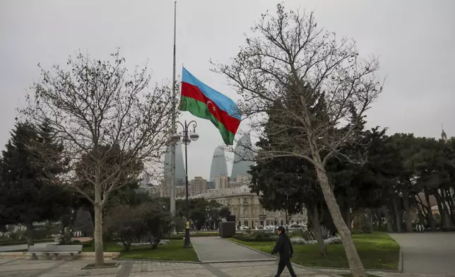 Azerbaijan's national flag at half-mast in the memory of victims of the Azerbaijan Airlines' Embraer 190 that crashed near the Kazakhstan's airport of Aktau, is seen in the center of Baku, Azerbaijan, Thursday, Dec. 26, 2024. (AP Photo/Aziz Karimov)