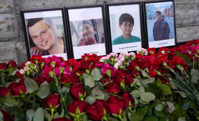 Flowers and portraits are placed at the Consulate of Azerbaijan in the memory of victims of the Azerbaijan Airlines' Embraer 190 that crashed near the Kazakhstan's airport of Aktau, in St. Petersburg, Russia, Thursday, Dec. 26, 2024. (AP Photo/Dmitri Lovetsky)