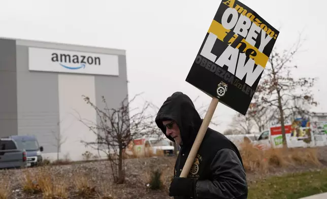 A striker holds a sign during a strike at Skokie (DIL7) Amazon Delivery station in Skokie, Ill., Thursday, Dec. 19, 2024. (AP Photo/Nam Y. Huh)