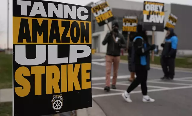 Strikers hold signs during a strike at Skokie (DIL7) Amazon Delivery station in Skokie, Ill., Thursday, Dec. 19, 2024. (AP Photo/Nam Y. Huh)