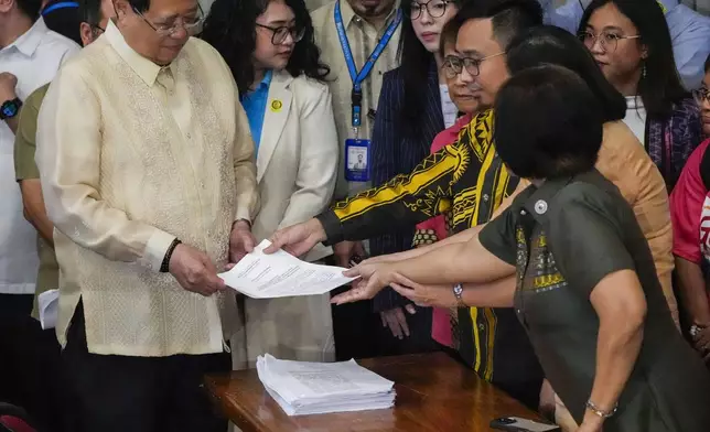 House Secretary General, Reginald Velasco, left, receives a second impeachment complaint filed against Philippine Vice President Sara Duterte by a group led by left-wing activists on Wednesday Dec. 4, 2024 at the House of Representatives in Quezon City, Philippines. (AP Photo/Aaron Favila)