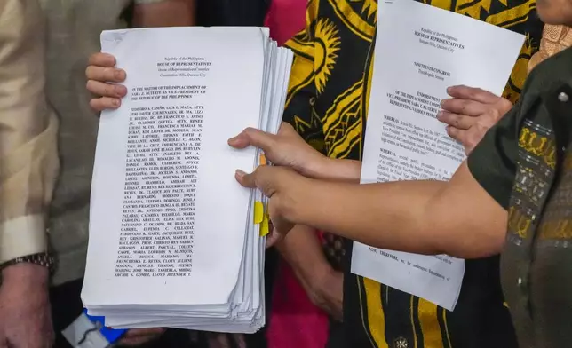 Activists hold a copy of a second impeachment complaint filed against Philippine Vice President Sara Duterte on Wednesday Dec. 4, 2024 at the House of Representatives in Quezon City, Philippines. (AP Photo/Aaron Favila)