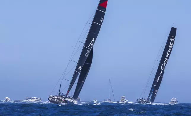 Master Lock Comanche, left, and LawConnect sail out of the heads following the start of the Sydney to Hobart yacht race in Sydney, Thursday, Dec. 26, 2024. (Mark Evans/AAP Image via AP).