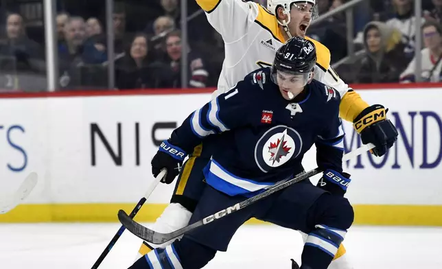 Nashville Predators' Colton Sissons, top, disputes a delayed hooking penalty against Winnipeg Jets' Cole Perfetti (91) during the second period of an NHL hockey game in Winnipeg, Manitoba, Monday, Dec. 30, 2024. (Fred Greenslade/The Canadian Press via AP)