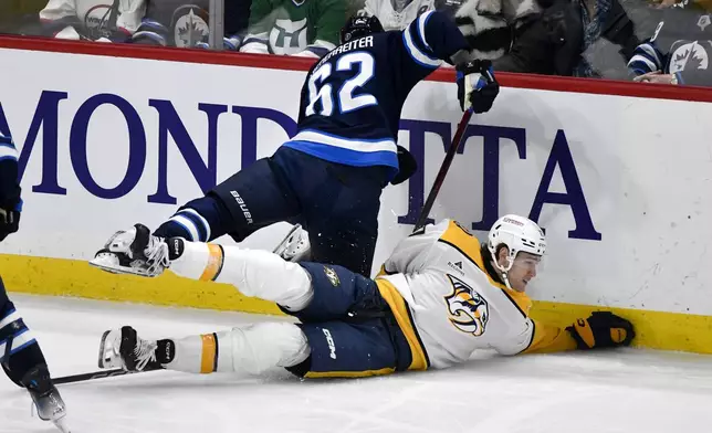 Nashville Predators' Mark Jankowski collides with Winnipeg Jets' Nino Niederreiter (62) during the first period of an NHL hockey game in Winnipeg, Manitoba, Monday, Dec. 30, 2024. (Fred Greenslade/The Canadian Press via AP)