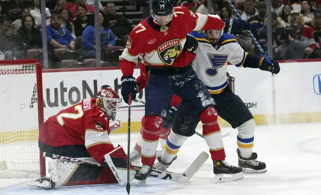 Florida Panthers goaltender Sergei Bobrovsky (72) and defenseman Niko Mikkola (77) defend the goal against St. Louis Blues defenseman Justin Faulk, right, during the first period of an NHL hockey game, Friday, Dec. 20, 2024, in Sunrise, Fla. (AP Photo/Lynne Sladky)