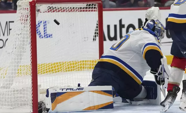 The puck gets past St. Louis Blues goaltender Joel Hofer on a goal scored by Florida Panthers defenseman Uvis Balinskis during the second period of an NHL hockey game, Friday, Dec. 20, 2024, in Sunrise, Fla. (AP Photo/Lynne Sladky)