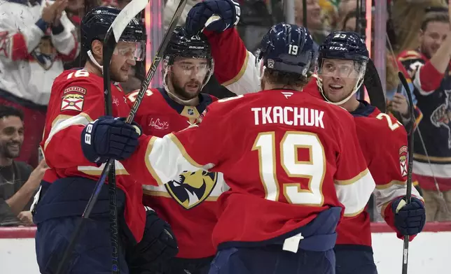 Florida Panthers defenseman Uvis Balinskis, second from left, is congratulated after scoring a goal during the second period of an NHL hockey game against the St. Louis Blues, Friday, Dec. 20, 2024, in Sunrise, Fla. (AP Photo/Lynne Sladky)