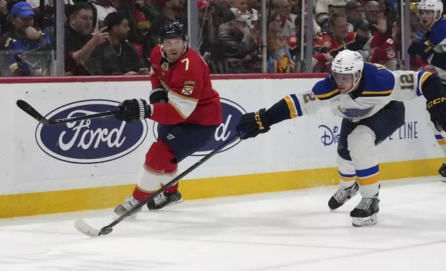 St. Louis Blues center Radek Faksa (12) skates with the puck as Florida Panthers defenseman Dmitry Kulikov (7) defends during the first period of an NHL hockey game, Friday, Dec. 20, 2024, in Sunrise, Fla. (AP Photo/Lynne Sladky)