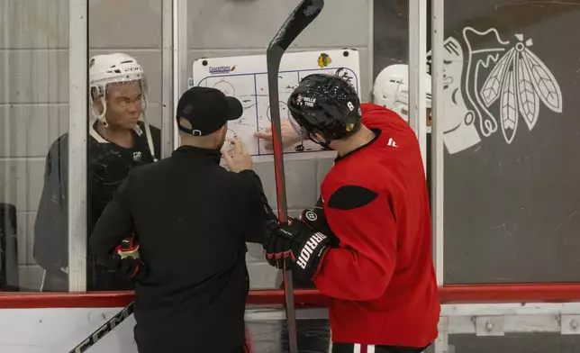 Chicago Blackhawks interim head coach Anders Sorensen and Ryan Donato (8) discuss drills during NHL hockey practice at Fifth Third Arena, Friday, Dec. 6, 2024. (Ashlee Rezin/Chicago Sun-Times via AP)