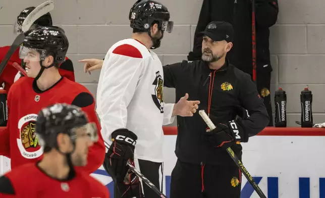 Chicago Blackhawks interim head coach Anders Sorensen speaks with Jason Dickinson (16) during NHL hockey practice at Fifth Third Arena, Friday, Dec. 6, 2024. (Ashlee Rezin/Chicago Sun-Times via AP)