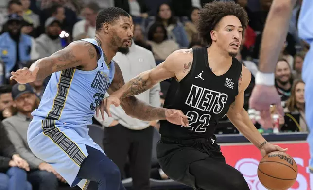 Brooklyn Nets forward Jalen Wilson (22) handles the ball against Memphis Grizzlies guard Marcus Smart (36) in the first half of an NBA basketball game Friday, Dec. 13, 2024, in Memphis, Tenn. (AP Photo/Brandon Dill)