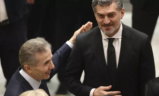 Georgian Dream party founder Bidzina Ivanishvili, left, embraces Georgian President-elect Mikheil Kavelashvili at his swearing-in ceremony at the Georgian Parliament in Tbilisi, Georgia, Sunday, Dec. 29, 2024. (Irakli Gedenidze/Pool Photo via AP)