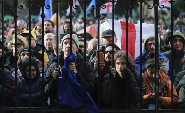 People listen to outgoing Georgian President Salome Zourabichvili speaking outside of the Orbeliani Palace, the official residence of the President of Georgia, in Tbilisi, Georgia, Sunday, Dec. 29, 2024. (AP Photo/Zurab Tsertsvadze)