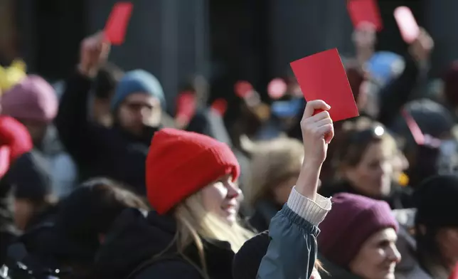 Demonstrators hold red cards outside of the Georgian parliament where the President-elect Mikheil Kavelashvili, a former soccer player, takes his oath at the swearing-in ceremony, in Tbilisi, Georgia, Sunday, Dec. 29, 2024. (AP Photo/Zurab Tsertsvadze)