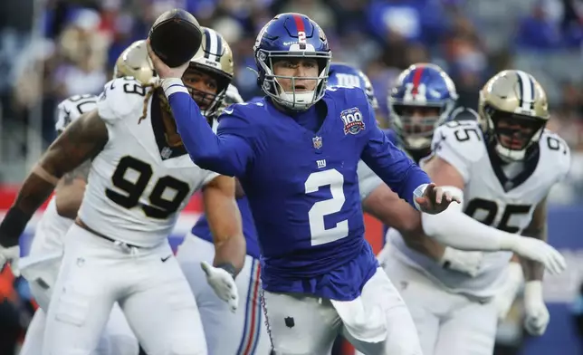 New York Giants quarterback Drew Lock (2) passes under pressure against the New Orleans Saints during the third quarter of an NFL football game, Sunday, Dec. 8, 2024, in East Rutherford, N.J. (AP Photo/John Munson)