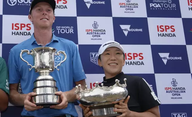 Ryggs Johnston, left, of the United States and Jiyai Shin of Korea hold their trophies after winning the Australian Open golf championship at the Kingston Heath Golf Club in Melbourne, Australia, Sunday, Dec. 1, 2024. (AP Photo/Asanka Brendon Ratnayake)