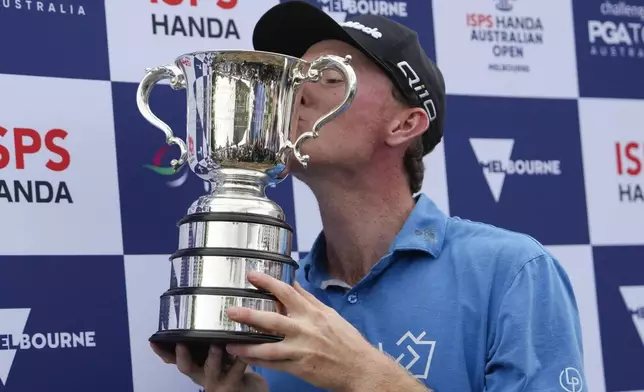 Ryggs Johnston of the United States kisses the Stonehaven Cup after winning the Australian Open golf championship at the Kingston Heath Golf Club in Melbourne, Australia, Sunday, Dec. 1, 2024. (AP Photo/Asanka Brendon Ratnayake)